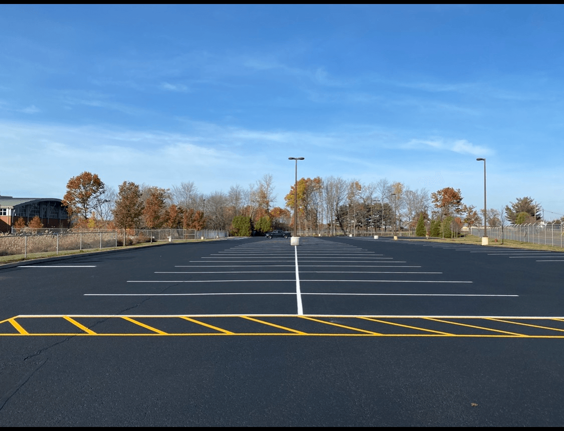 Freshly sealcoated Connecticut commercial parking lot with crisp yellow striping by U-SEAL USA